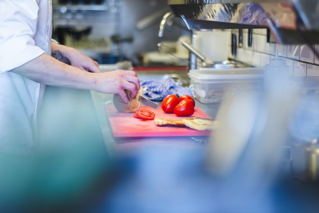 Kitchen worker preparing fresh produce at a prep station